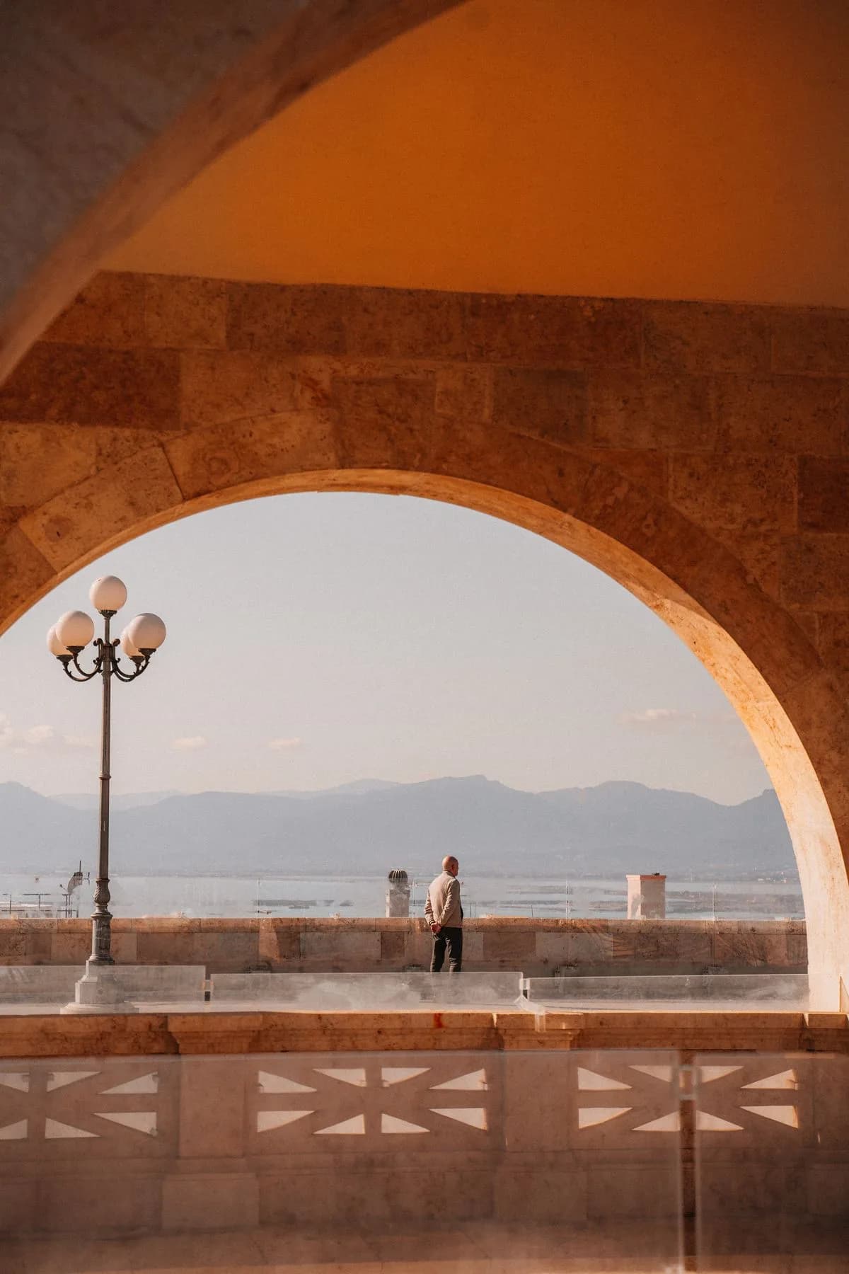 Un arco in pietra incornicia il mare a Cagliari