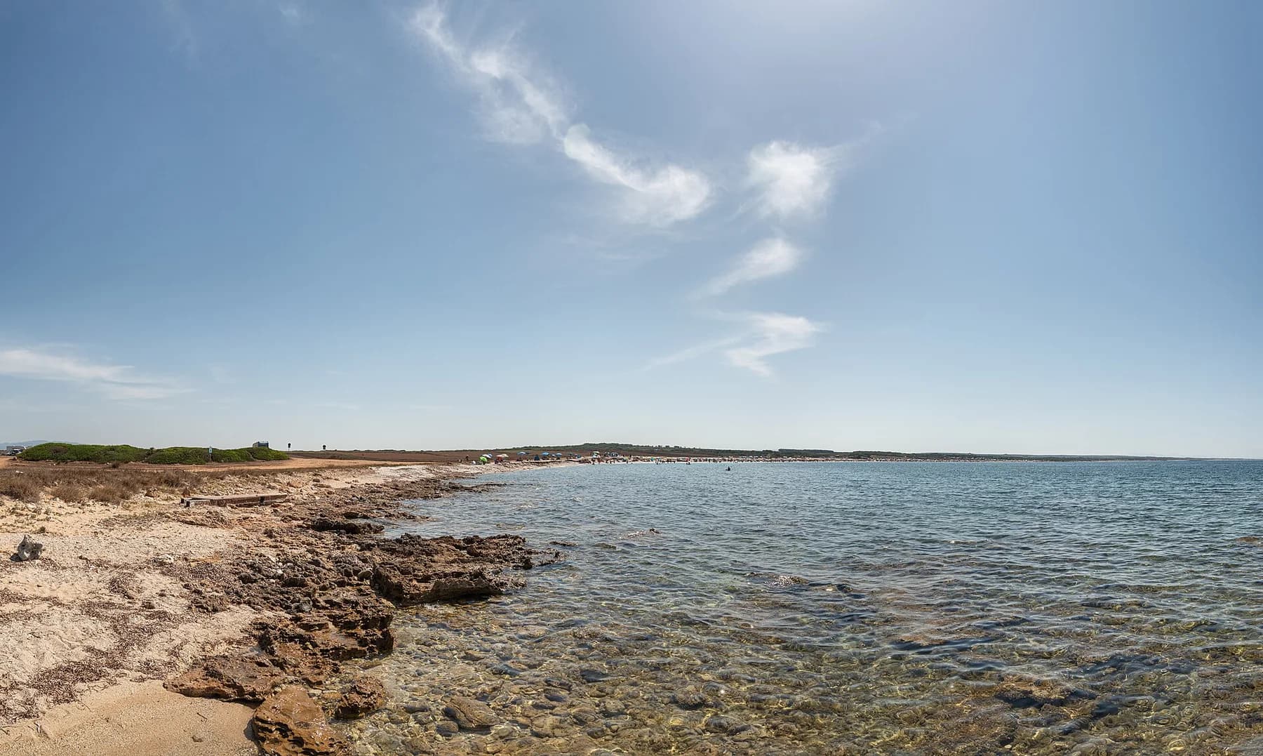 Costa rocciosa e acqua limpida accanto alla spiaggia di Mari Ermi nel Sinis